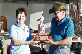 Sheila Sparks receiving the Dr Tom Wright Memorial Trophy from Wooden Boat Association of Cairns Vice President Chris O’Keefe for winning the Seagull Outboard Race. (PHOTO: Glen Chisholm)