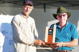 Dermot Smyth, Wooden Boat Association of Cairns Secretary, presenting the Peculiar Propulsion Race trophy to Chris O’Keefe after victory in his very peculiar pedal-powered paddle-wheeler. (PHOTO: Glen Chisholm)