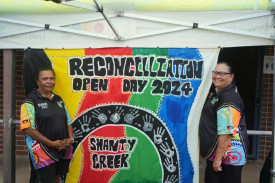 Shanty Creek staff Jenni Callope and Judy Anderson by the resident painted event sign.