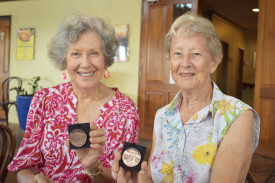 Fay McGrath and Betty Bird show off the specially made medals given to the volunteers.