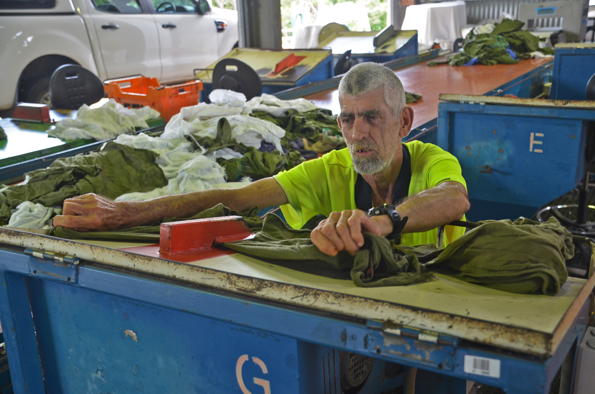 Employee Frank Woods cuts second-hand cloth that is then used to make cleaning cloth.