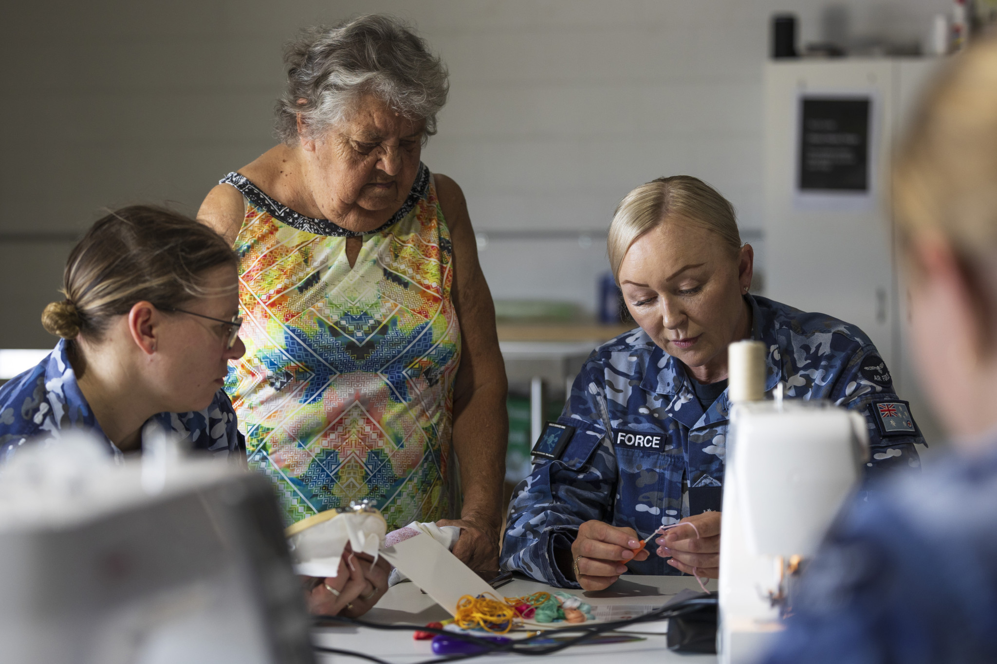 Warrant Officer Cathleen Browning (right), from Headquarters Health Services Wing, chats with Aunty Mary and Wing Commander Elisha Kropp during the weekly women’s sewing session held at Mareeba.