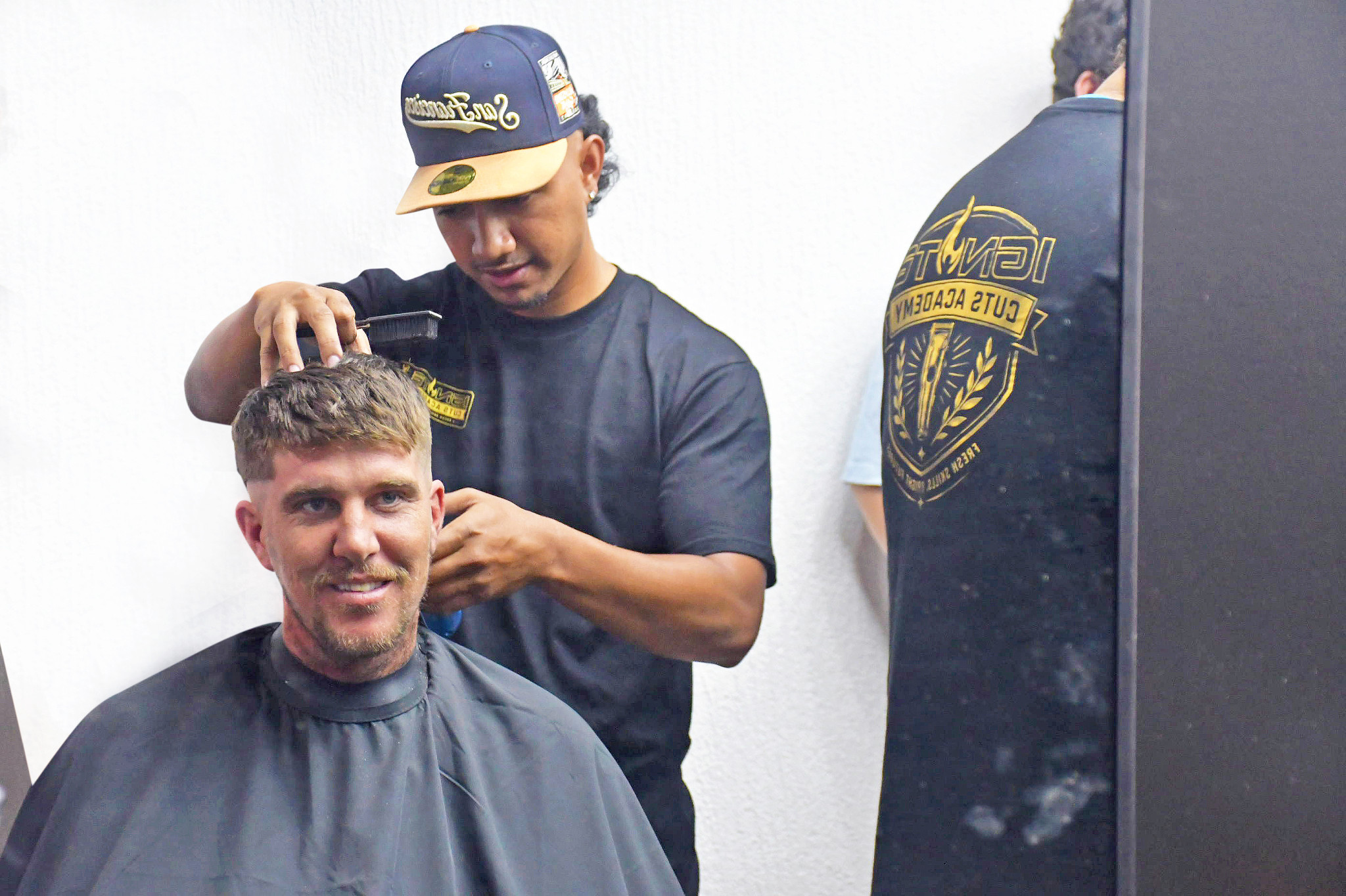 Men lined up for haircuts at the opening of the community hub at 99 Byrnes Street.