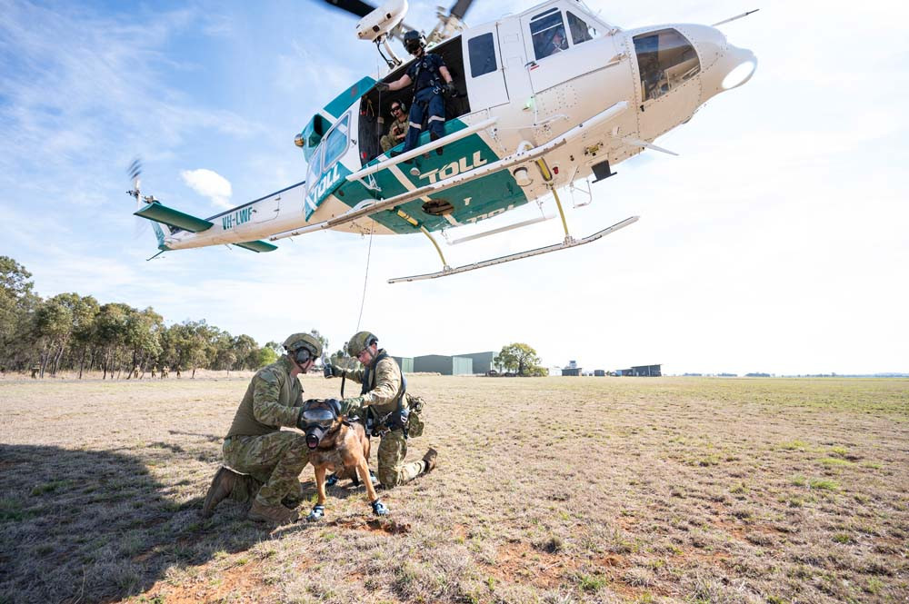 Sergeant Samuel Milliner (right) prepares Sergeant Duilio Di Pasquale and Military Police Dog Doza to hoist during the course.