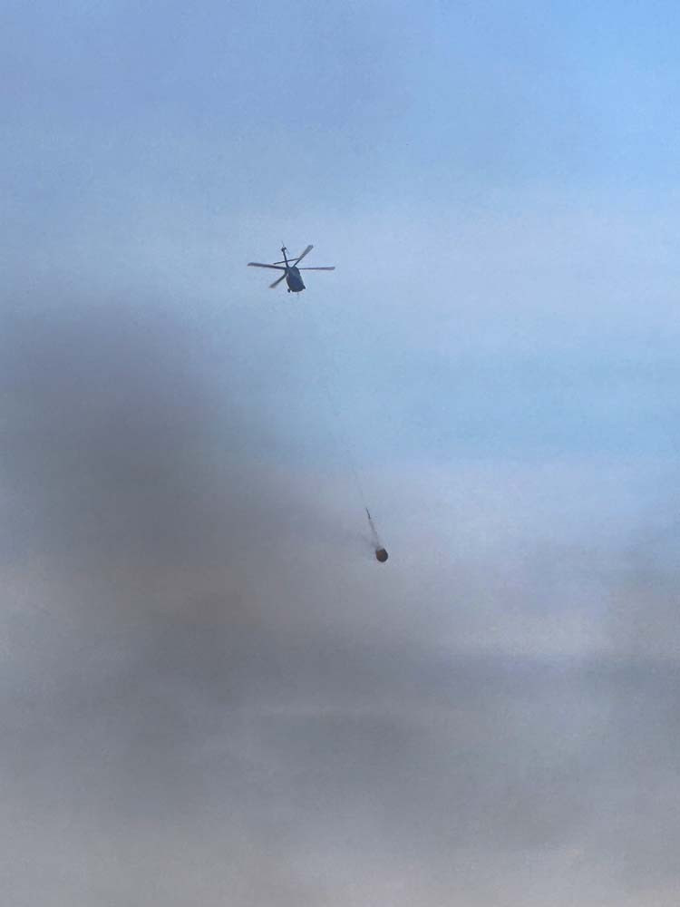 while the Black Hawk helicopter assists to douse fires near the town.