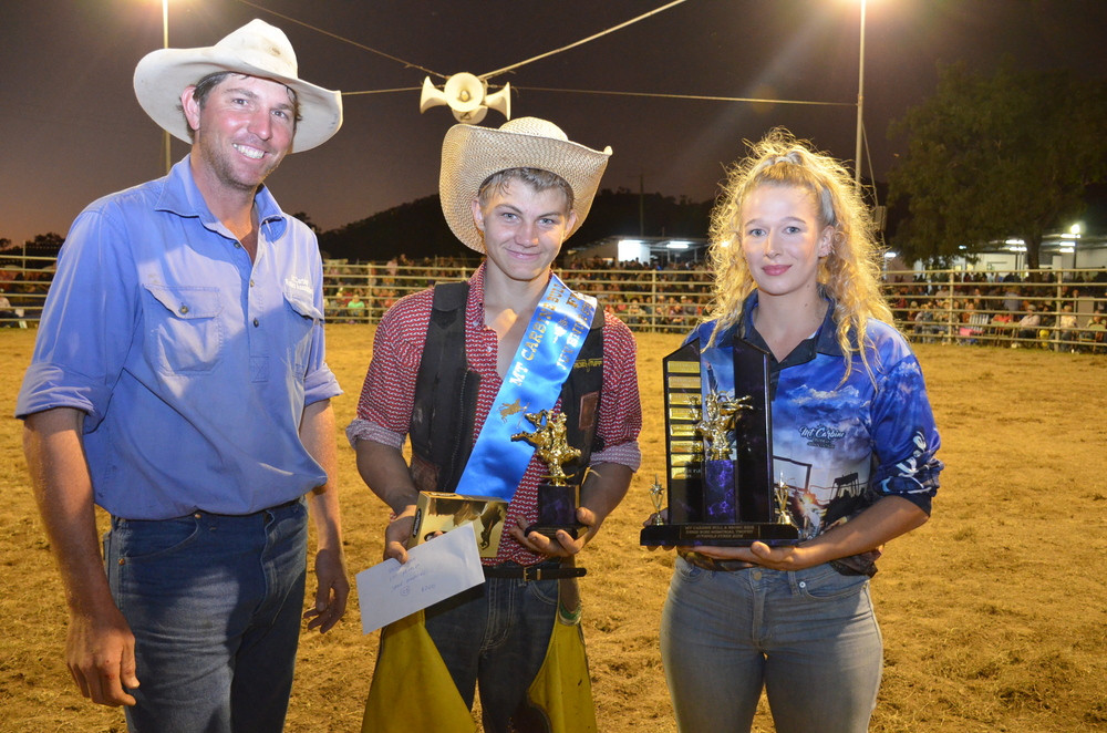 Jake Simpson of Mareeba won the Junior Bull Ride and Juvenile Steer on Saturday night and was presented with the Dennis Ross Memorial Trophy by family member Courtney Ross.