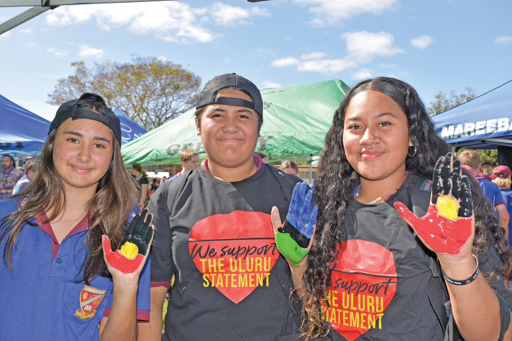 Mahlay Harbrow, Kevina Ngan-woo and Jehaziel Kose painted their hands with Aboriginal and Torres Strait Island flags before putting them on a hand tree.
