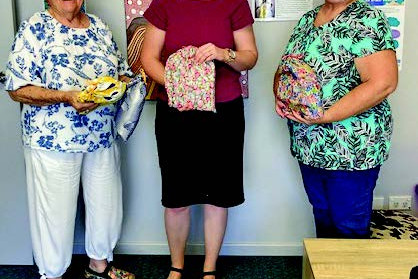 QCWA Mareeba president Jessie Richardson (left) and vice president Helen Elmes hand over the care bags to Senior Practitioner Kathryn at the Mareeba Domestic Violence Centre.