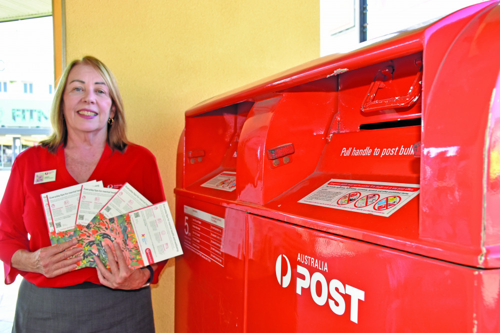 Postal Manager of the Mareeba Post Office Eileen Cummins with the free postcards.