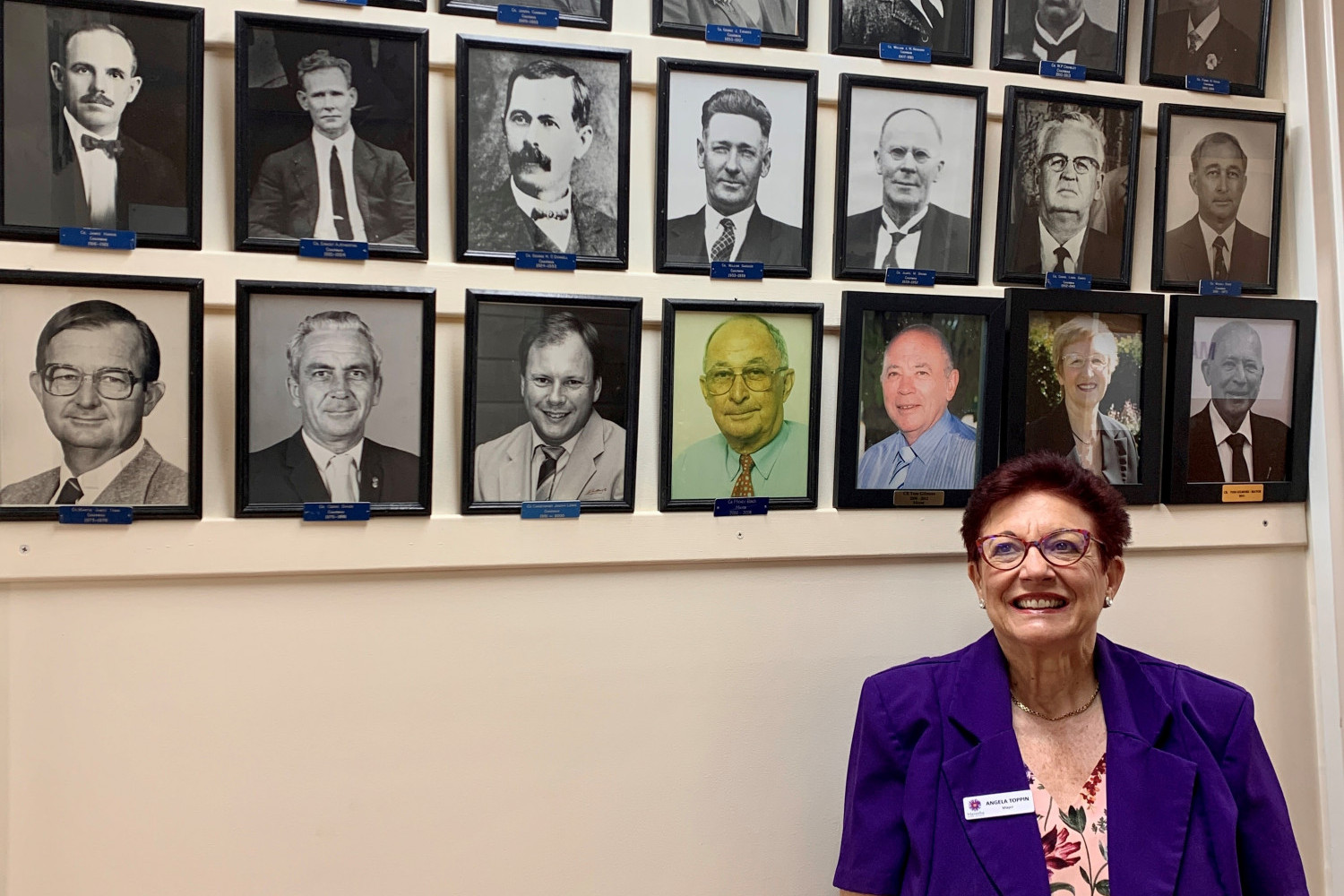 Cr Angela Toppin in front of a wall of previous Mayors.