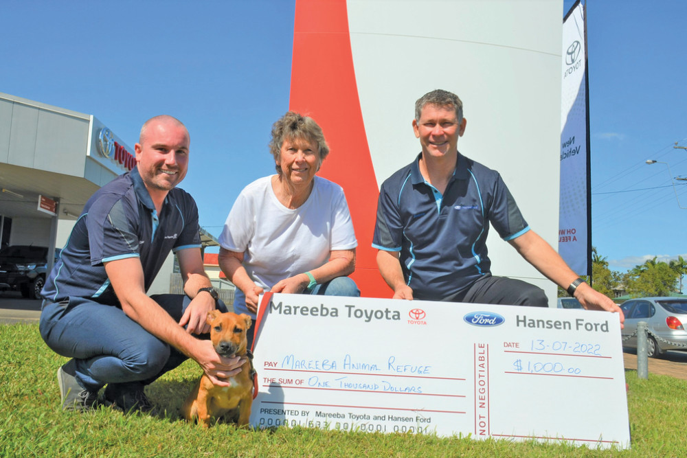 Mareeba Toyota sales consultant Drew McKenzie and sales manager Andrew Ford with Mareeba Animal Refuge manager Jennifer Walsh (centre) and refuge resident puppy Emerald who accepted their $1000 last week.