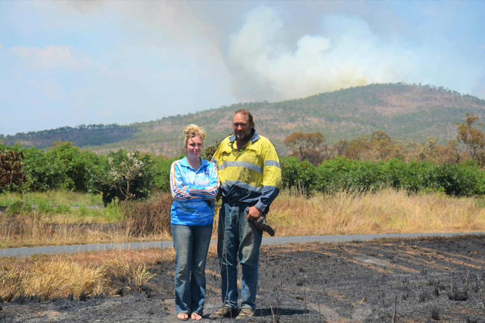 Damon Westwood and his daughter Sarah standing on their burnt property as fires continue to burn in the hills.