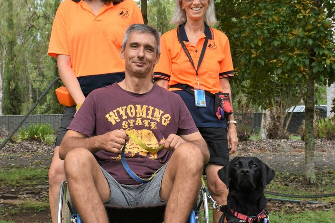Trainers Carly Starr and Ann Pierson with carer Tony Vlahovic with six month old assistant dog in training Lily.