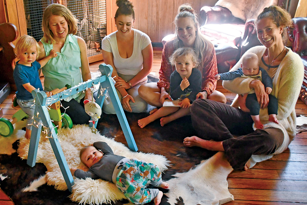 From left, Jeralyn Mawdsley and her son Micah, Sarah Curcio and her son Gus (lying on the rug), Madison Blain who has had to pay out for her home births, with her son Stryder, and midwife Tanya Fleming holding Madison’s son Wolfgang.