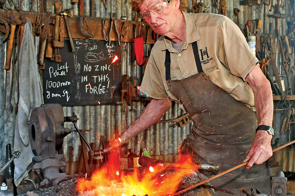 Herberton Historical Village curator and resident blacksmith Darryl Cooper loves to work with metal and inspire young kids with his work.