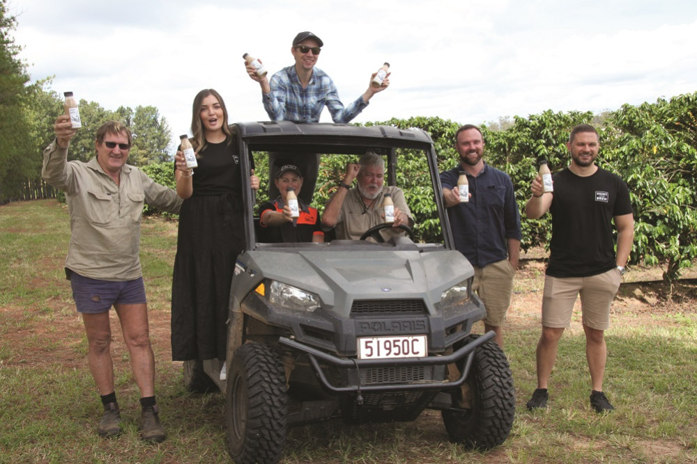 Godfrey Farm, Arriga, manager, Bill Price (L), expert coffee grower, Vitaliy Krutikov (back of buggy), Senior Brand Manager for Hunt and Brew, Emily Creer, General Manager of Howe Farming, Kim Mastin, Managing Director of Howe Farming, Dennis Howe, Howe Farming Administration Officer, Thomaz Charuk and Woolworth's Sydney Category Manager for dairy products, Lang Juckes, celebrate the launch of the new cold brew coffee made with Tableland Arabica beans.