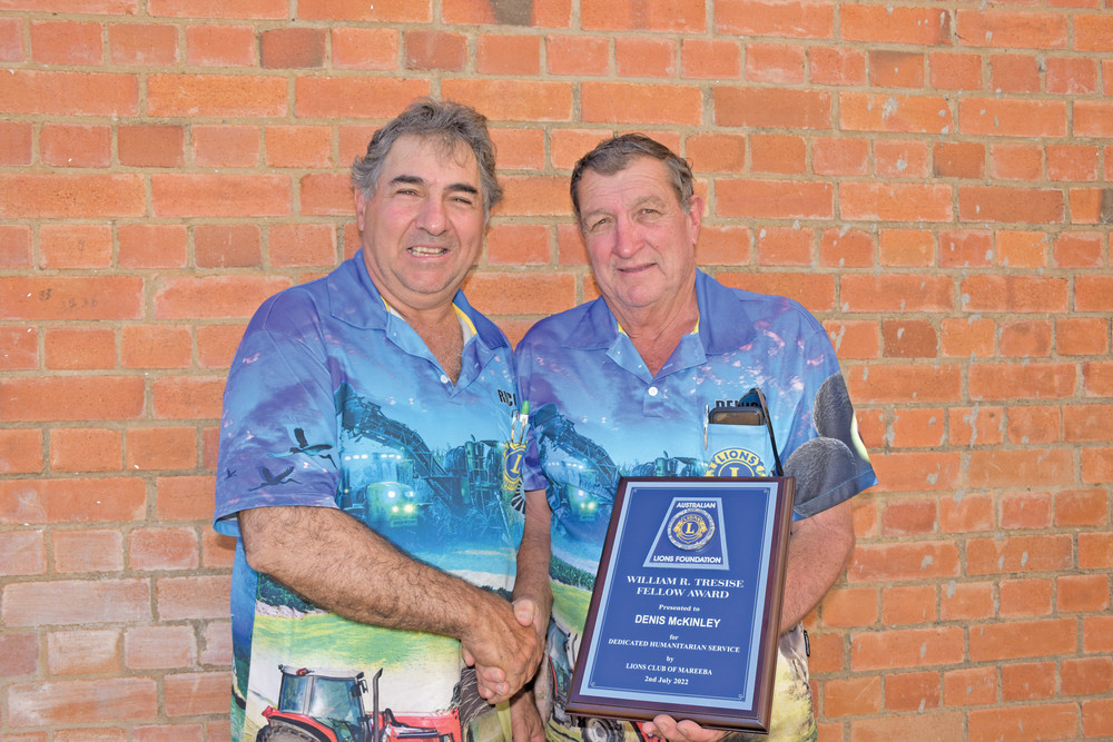 Mareeba Lions president Rico Cabassi handing the William R Tresise Fellowship Award to longstanding Lion Denis McKinley.