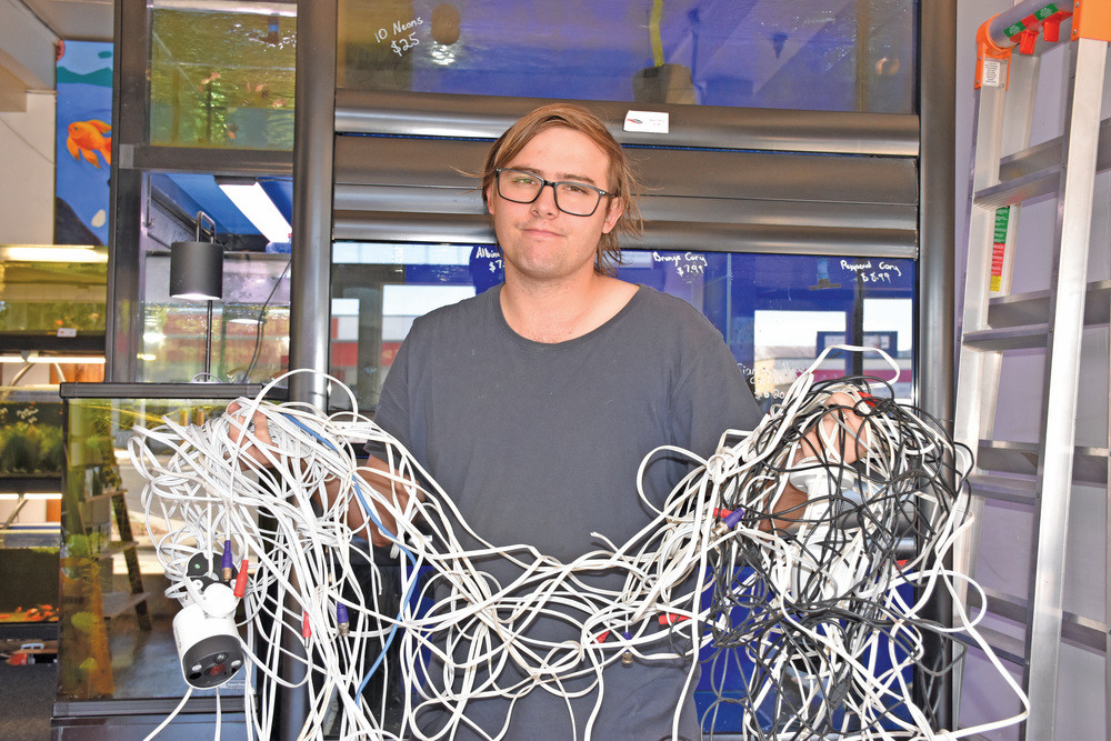 Fantasy Tails owner Zach Kroonenburg with the mass of CCTV camera wiring which was cut during a recent break-in.