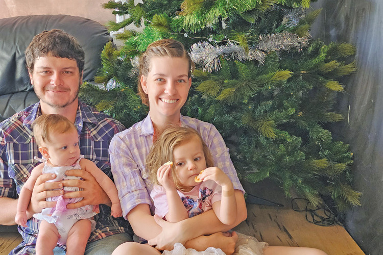 Shane and Ember Raymond and their girls Archer and Olivia under their Christmas tree.