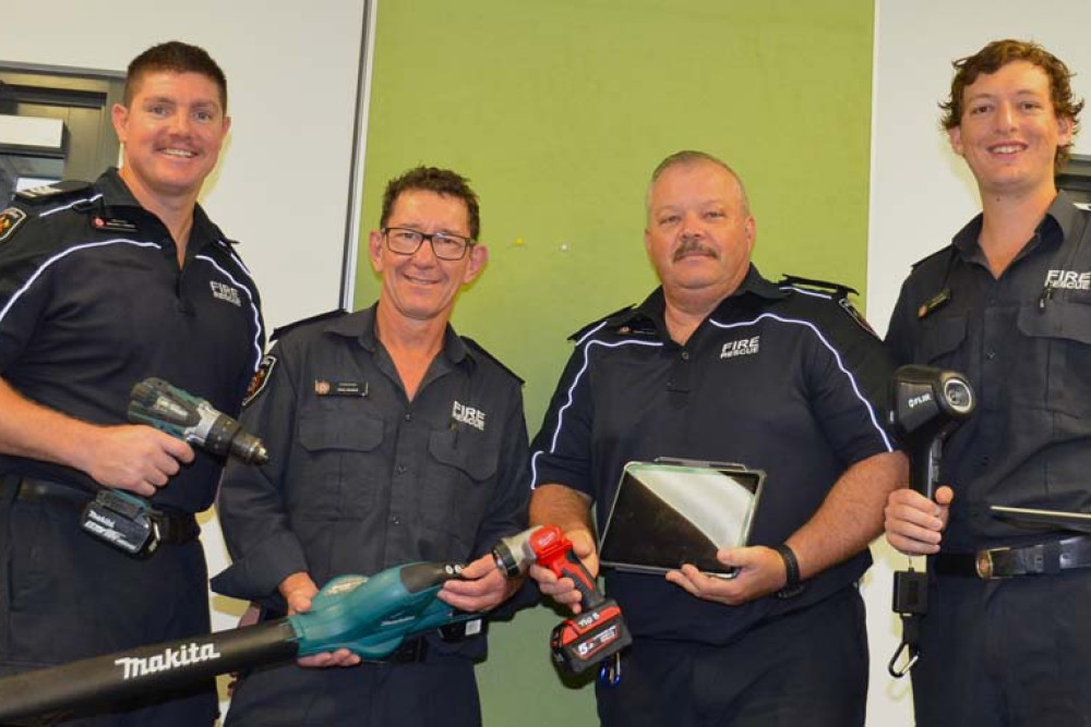Mareeba Fire Station auxiliary firefighters Micthell Timmons, Paul Dilena, station officer Darryl Chaplain and Jared Hohns holding every day devices they use that contain lithium-ion batteries.