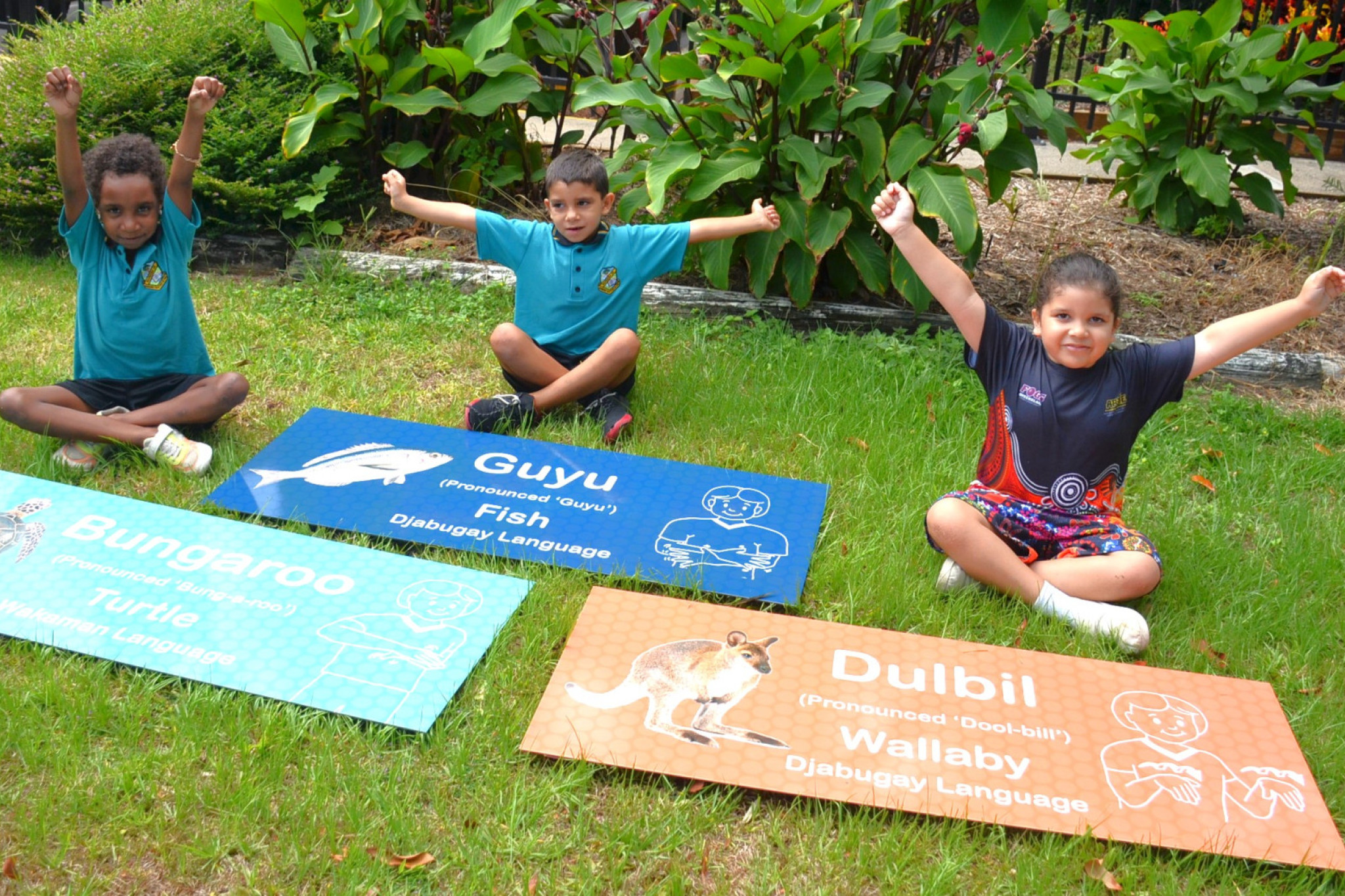 PICTURED: Prep students Sylvia Brumby-Gesa, Heath Hunter and Poppy Hunter with signs showing their language.