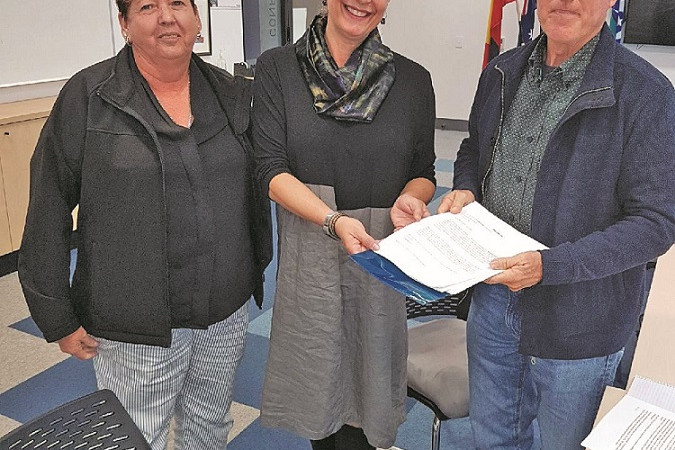 Herberton resident Stefanie Braun presents the petition to keep the Herberton Town Hall to Mayor Rod Marti and Cr Annette Haydon.