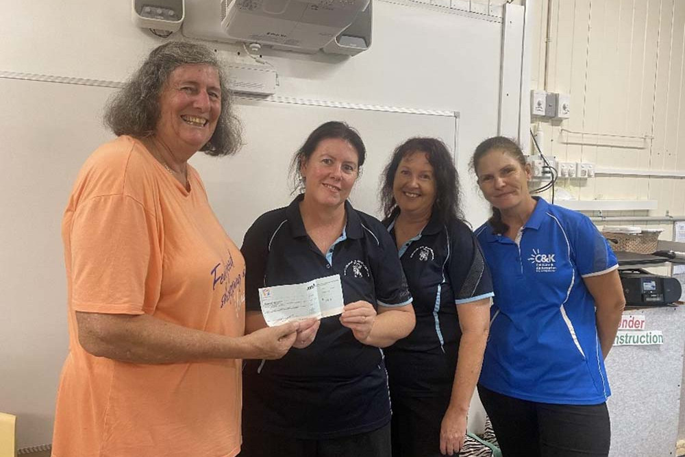 Doreen Mortimore presents one of the four cheques to Ravenshoe Kindy coordinator Karen and staff members Linda and Tash.
