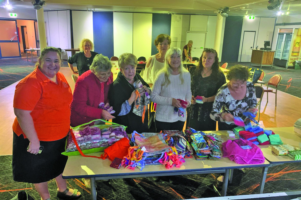 Lesa Moro with several Soroptimist members looking at all the components that make up the Days For Girls kits.