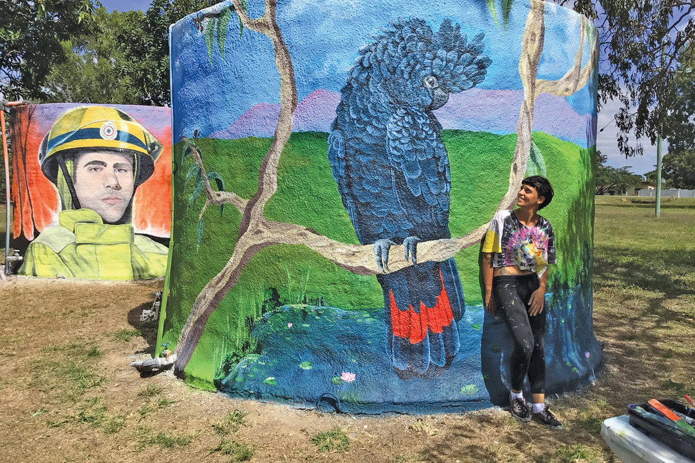 Artist Sara Dragotto with the newly painted murals on Biboohra’s old water tanks. PHOTO: Biboohra State School.
