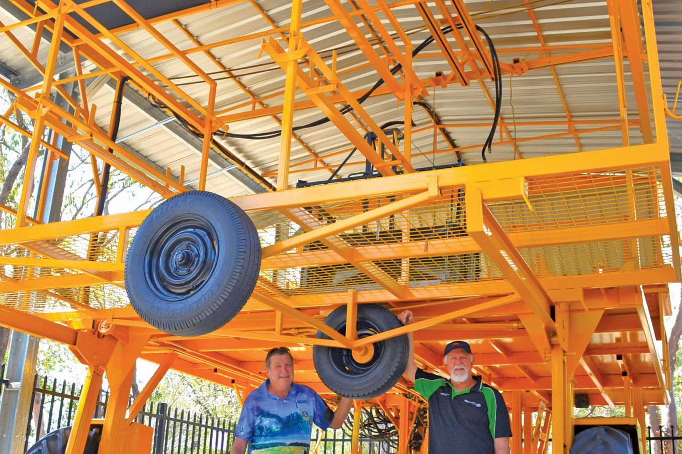 Mareeba Lions Club member Denis McKinley and Dimbulah Lions Club member Eddie Toffanello in front of a locally manufactured tobacco picking machine which is now on display in front of the Mareeba Heritage Museum.