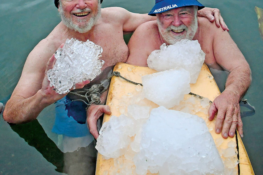 Swimmers Jim Petrich and Tony Rees have been using Lake Eacham for more than a decade for their daily swim and last week celebrated the start of winter with some icy blocks to add to the already cool water.