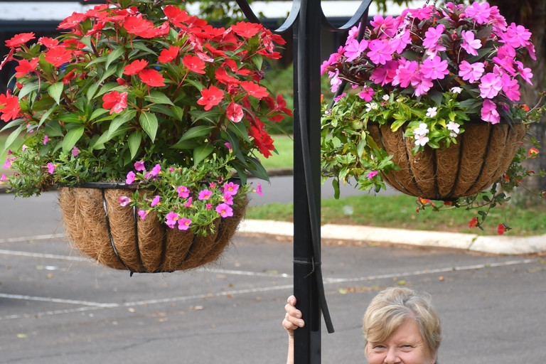 Yungaburra Beautification Inc president Sue Fairley with some of the beautiful flower baskets that line the town’s streets.