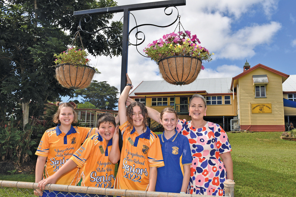 Yungaburra State School student leader Scarlett Hammersley, environmental leader Joey Donald, school leader Beth Borroli, student leader Leah Wither and principal Jo McDougall take pride in the flower baskets at the front of their school.