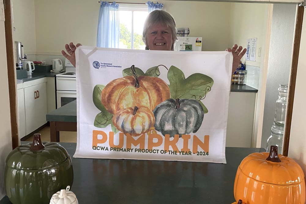 Margaret Plant, a member of the Millaa Millaa QCWA Branch and also an Atherton Tablelands Division vice president, proudly displays a specially designed 2024 QCWA Primary Product of the Year Pumpkin Tea Towel.