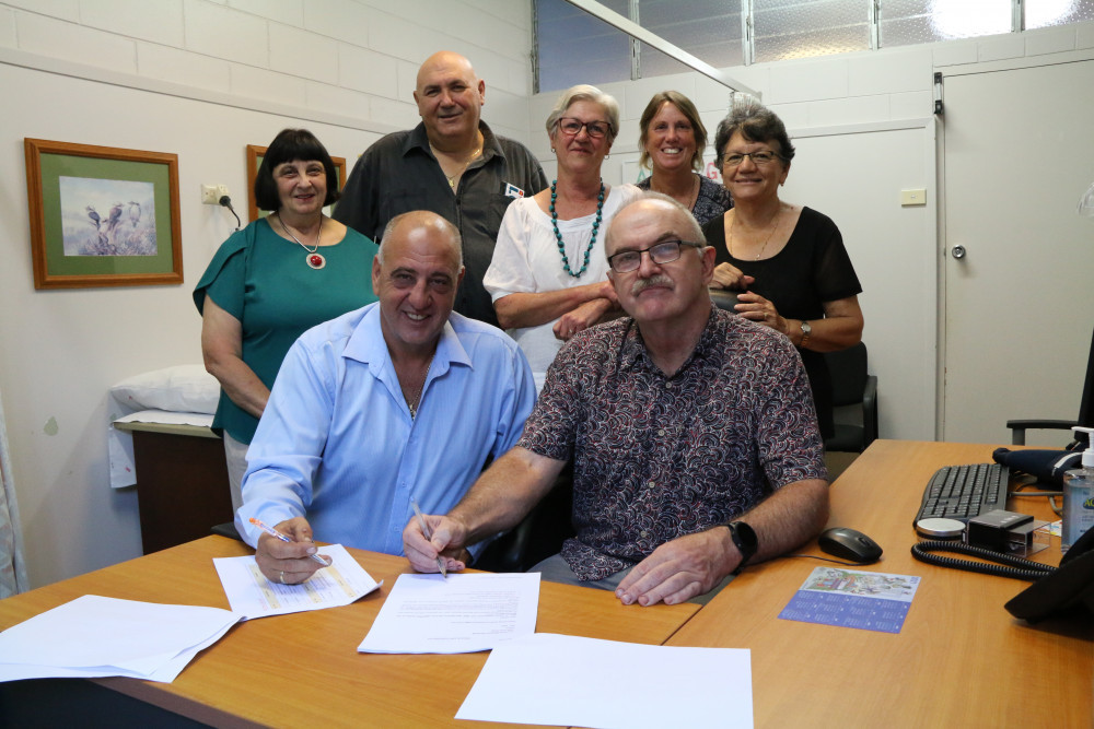 Mareeba Medical Clinic has transitioned ownership and is now being run by not-for-profit social enterprise, Mareeba and Communities Family Healthcare. Pictured are board members Mary Graham, board chairman Ross Cardillo, Joe Moro, project manager Louise Livingstone and Betty Dickenson with Dr Grant and Merril Manypeney as the papers are signed.