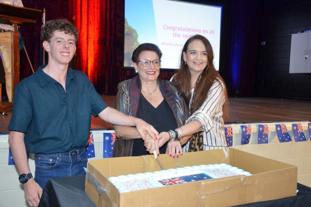 Henry Brammer, representing his brother and Young Citizen of the Year Nicholas, Mareeba Shire Mayor Angela Toppin and 2024 Citizen of the Year Natasha Srhoj cut the cake.