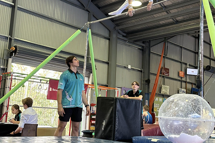 Coach Frank Tulloch with Finnlay Ford on the horizontal bars