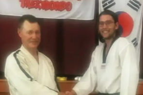 Kyle Muccignat (right) receiving his black belt from Master Instructor Phil Quayle.