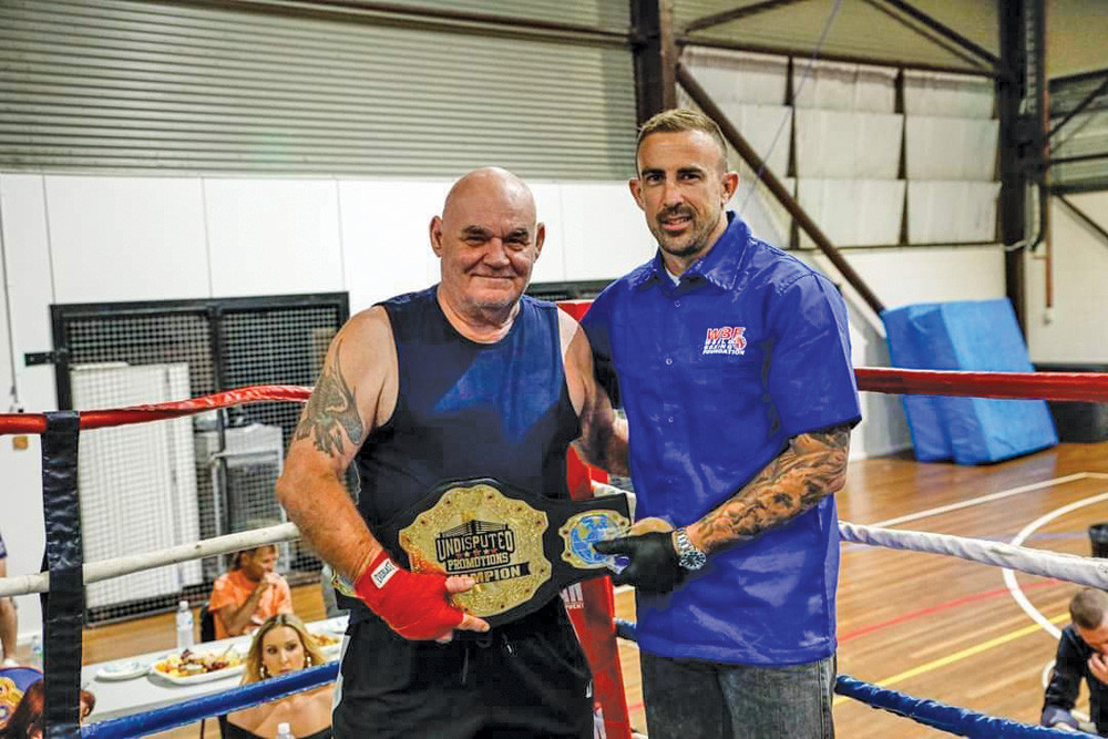 Mareeba veteran boxer Pinkie Csoma being awarded his belt by a referee after becoming an Australian Champion at his recent bout in Townsville.