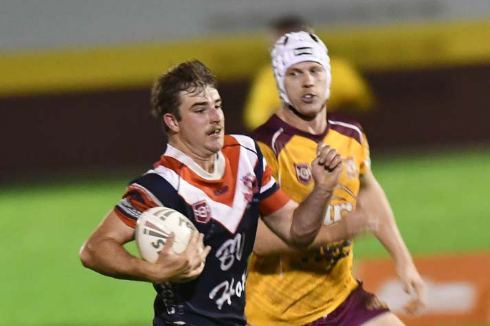 Roosters Oskar Coutts breaks through the Suburbs defence at Gordonvale on Saturday night.