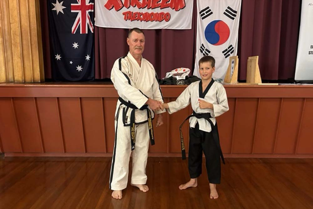 Master instructor Phil Quayle (left) with student James Kath, the 64th student to achieve a blackbelt in taekwondo at Dimbulah.