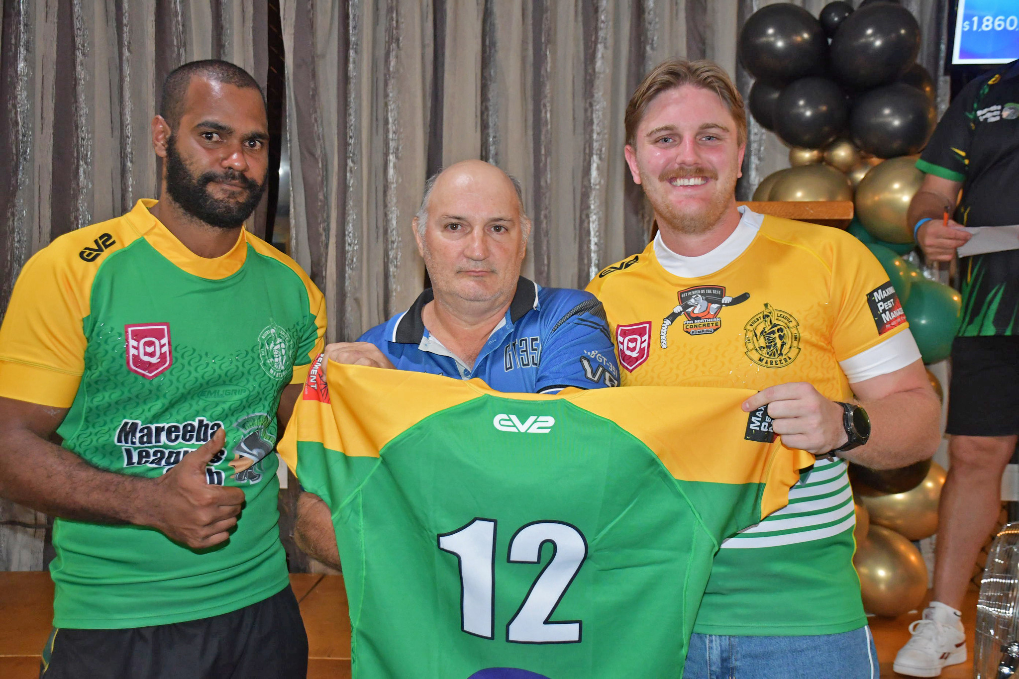 Back rowers Naeman Eustace (left) and Kyle Hastie (right) get a photo with Curcio’s Bakery owner Quinto Curcio, who bought the number 12 jersey for $2,250.
